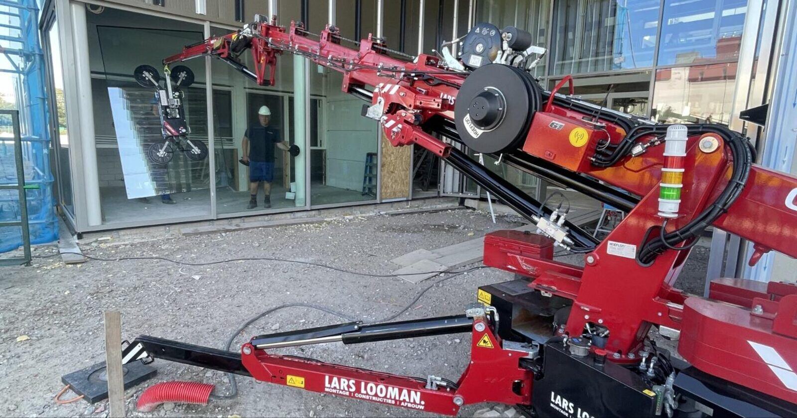 Mini hijskraan bij een bedrijfspand