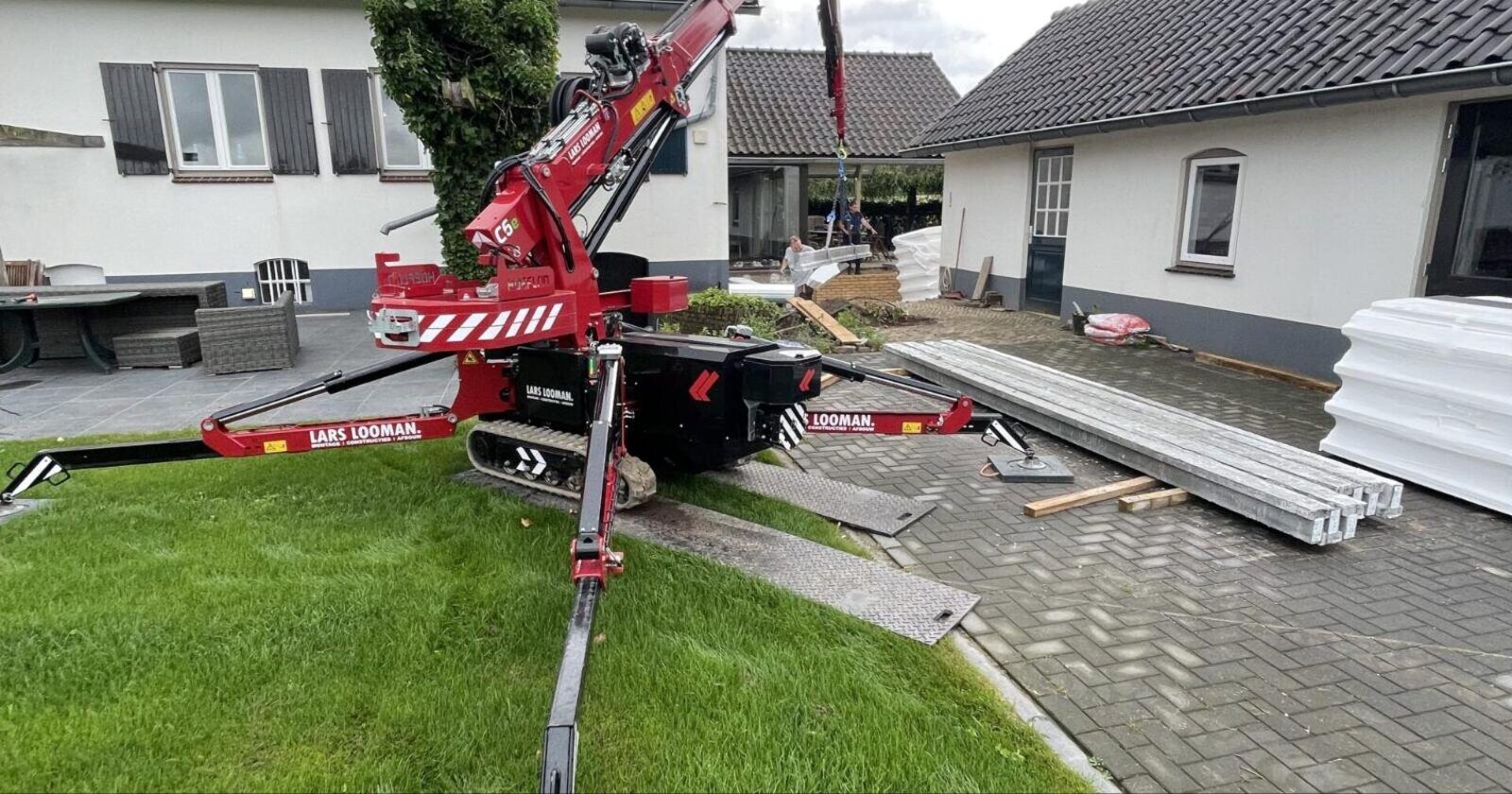 Mini hijskraan reikt elementen aan voor een broodjesvloer in Beek